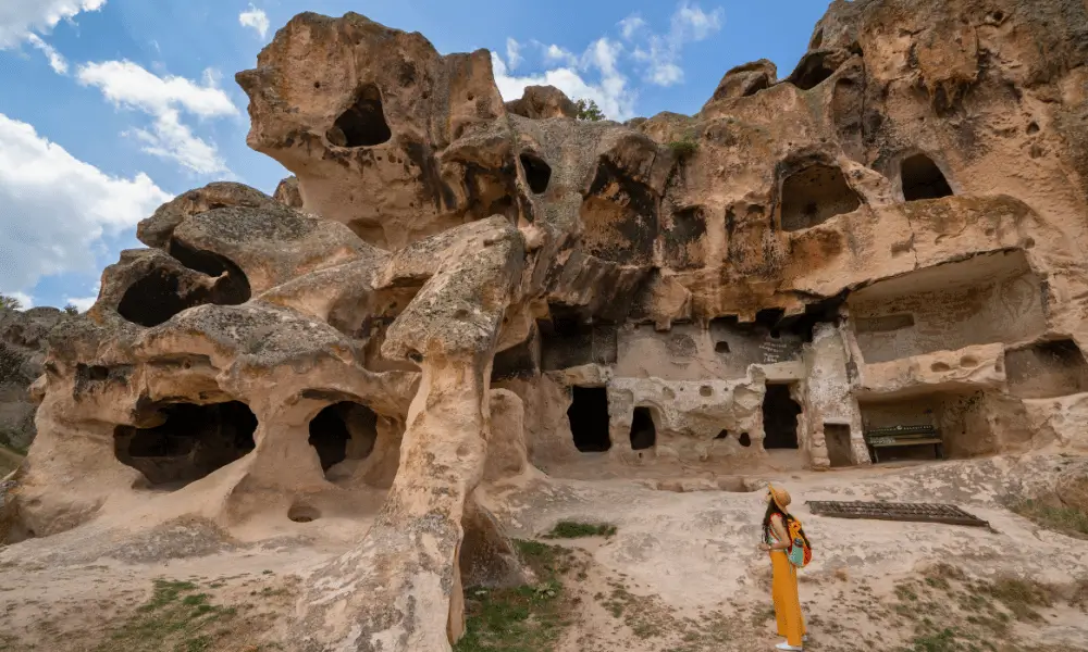 Yazılıkaya’da kayalara oyulmuş antik yaşam alanları ve bölgeyi gezen bir turist – Eskişehir Frig Vadisi